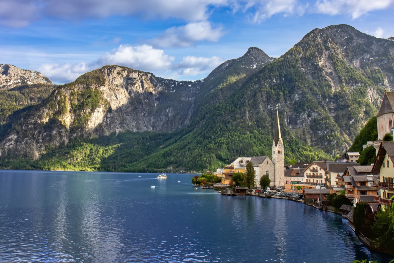 Hallstatt's church spire and houses on the lakeshore below steep mountains